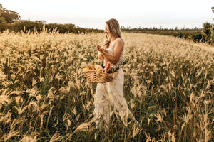 Mother walking through a wheat field holding a basket